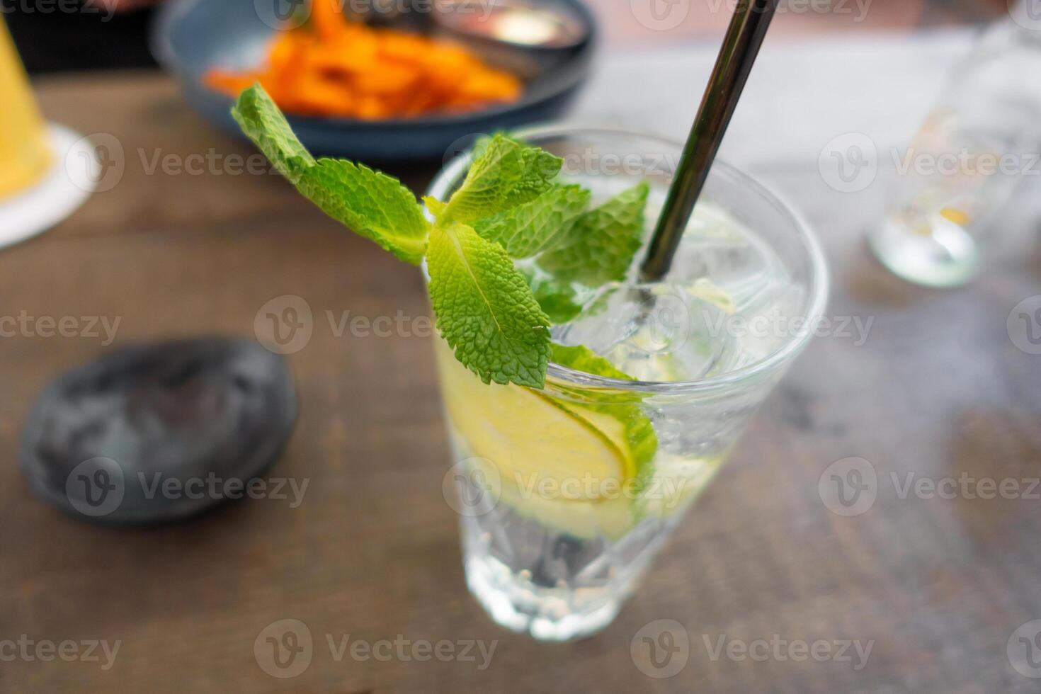 Lemonade with fresh lemon on wooden table background photo