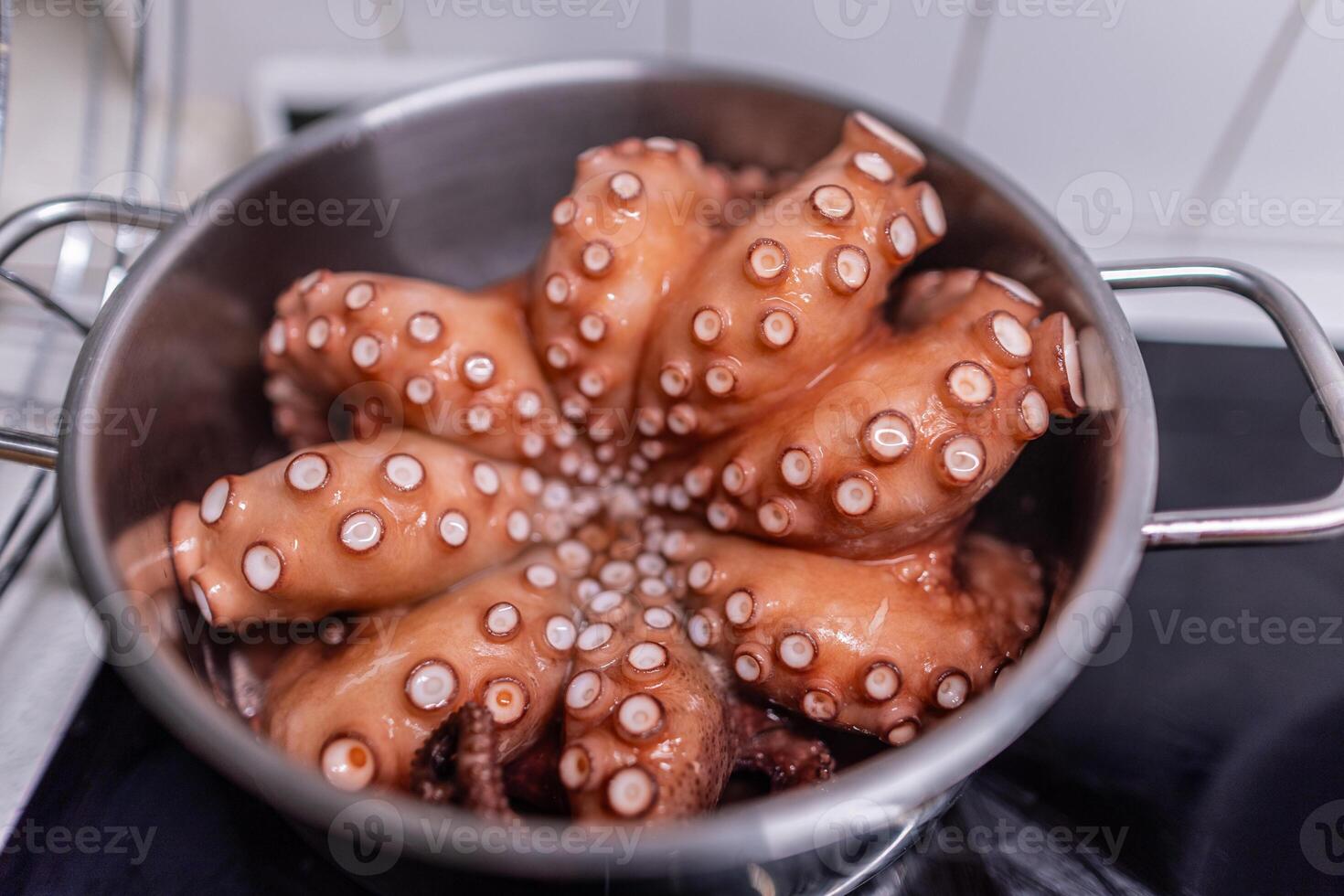 Boiled octopus is taken out of the pan. photo
