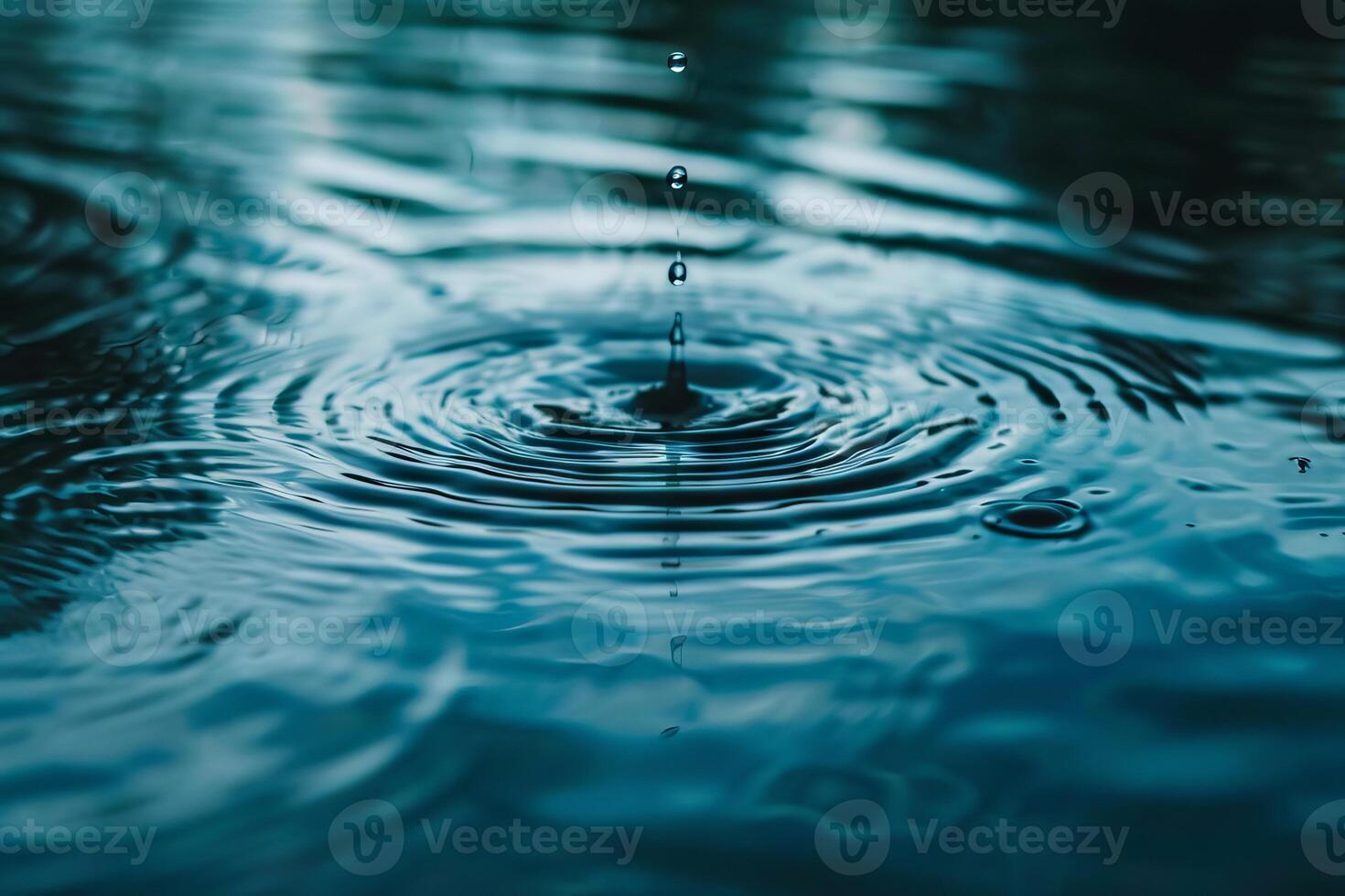 Gentle raindrops falling onto a calm body of water, creating ripples on the surface photo