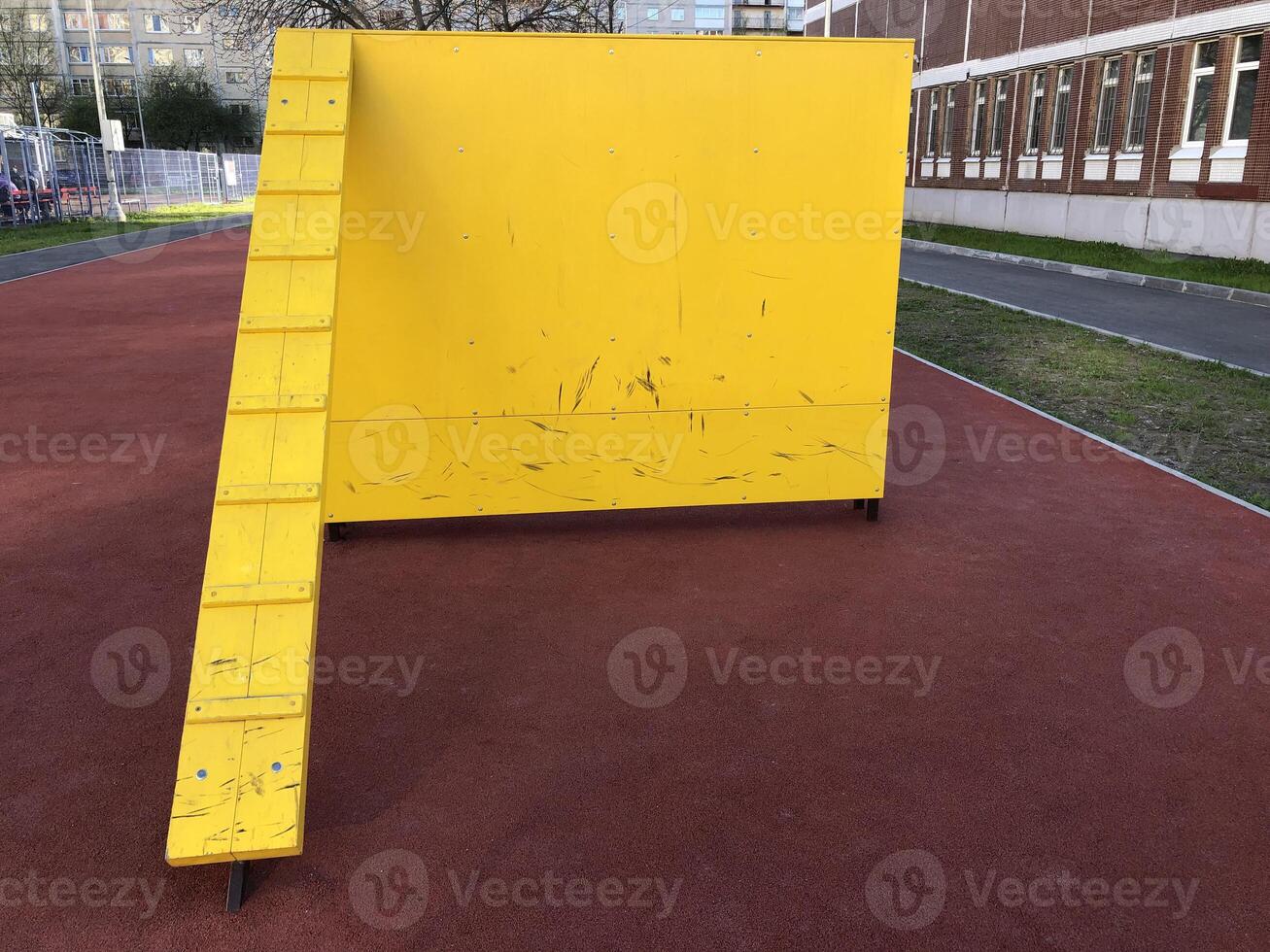 ladder to the yellow high wall of a gymnastics obstacle course photo