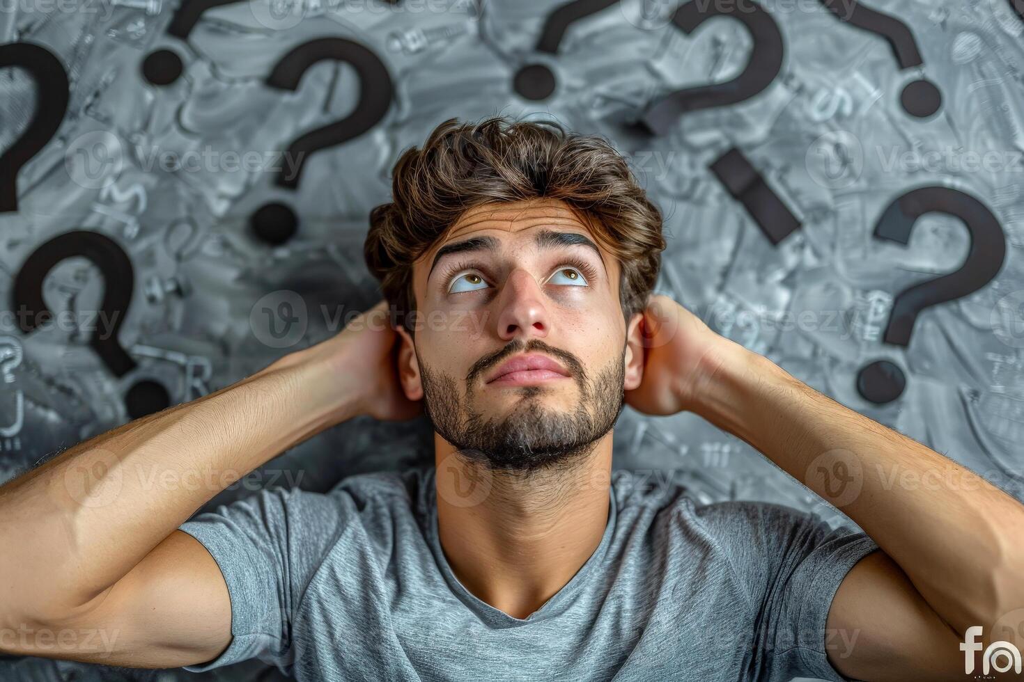 a man with perplexed facial expression and some question marks above his head. photo