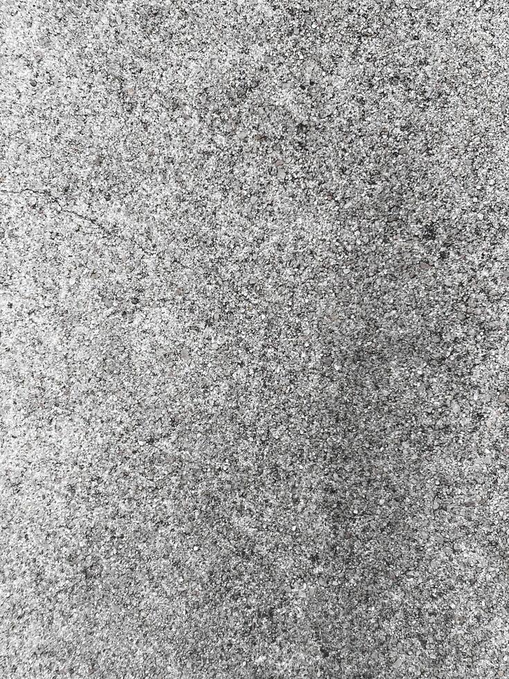 A white wall with a hole in it. The wall is cracked and has a rough texture photo