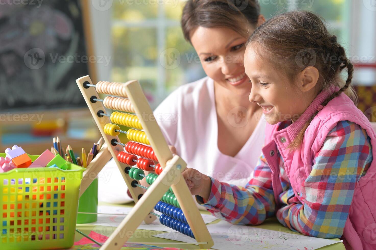 mother with little daughter counting with abacus photo