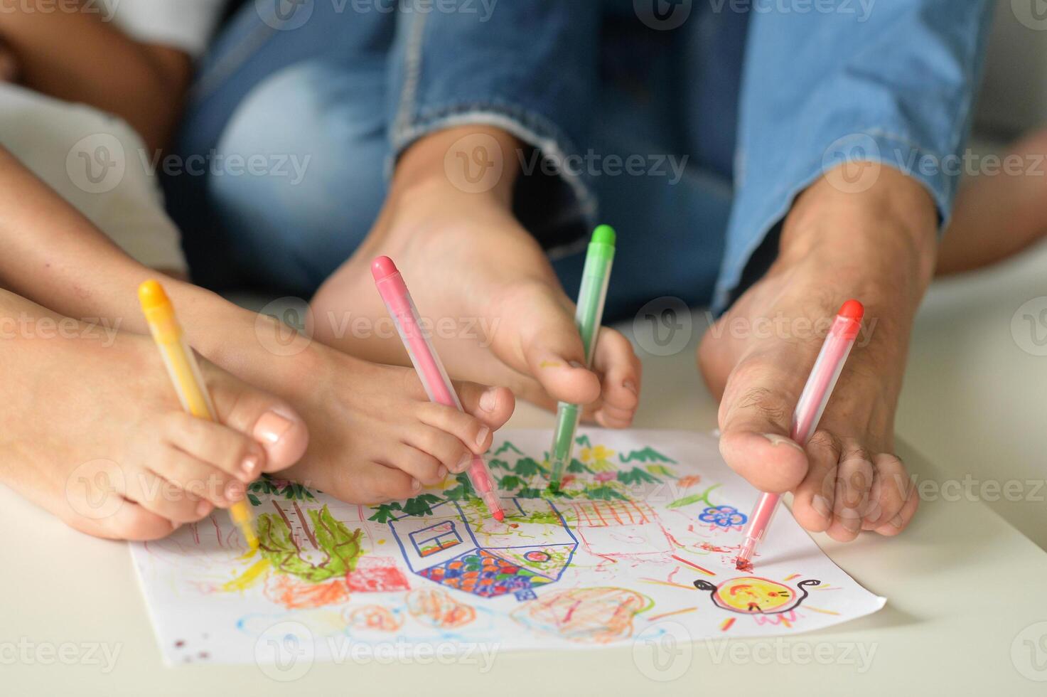 The family holds their pencils with their feet and draws photo