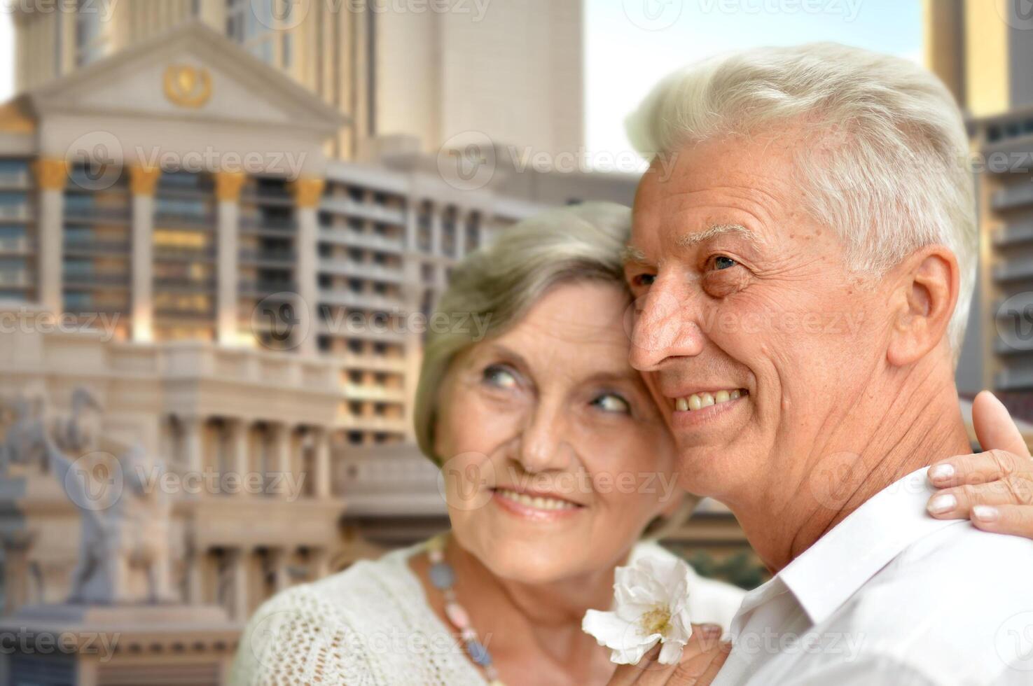 happy old couple hugging against city skyline photo