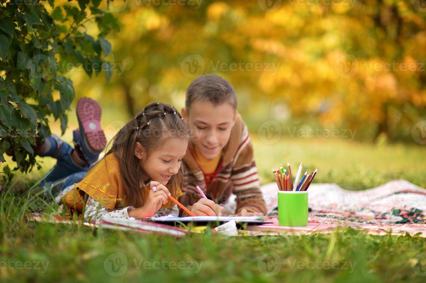 Girl and boy drawing in autumn park photo