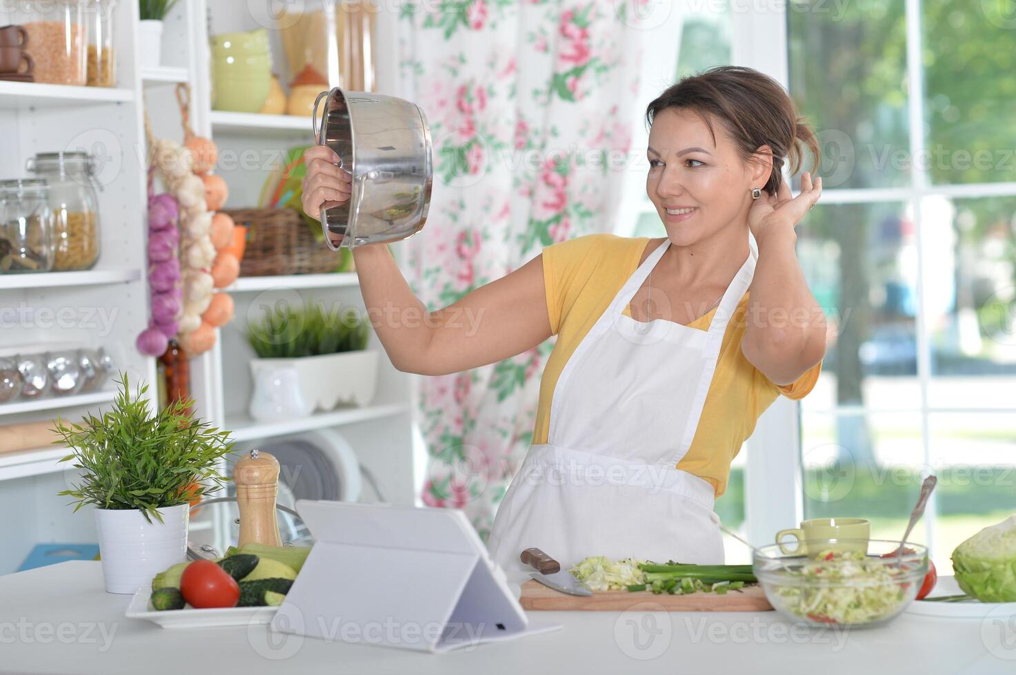 Portrait of beautiful young woman cooking dinner photo