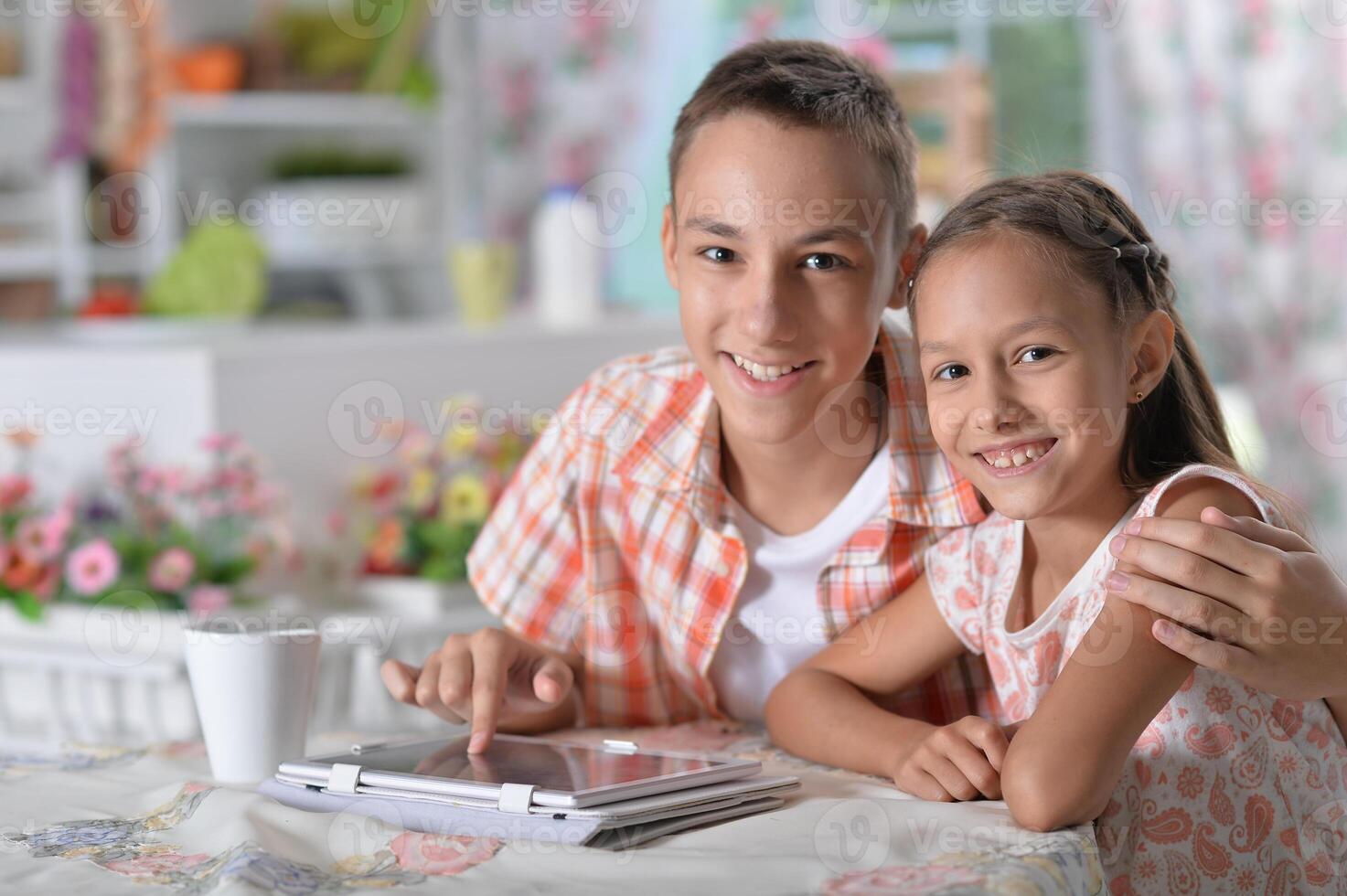 Portrait of brother and sister using tablet photo