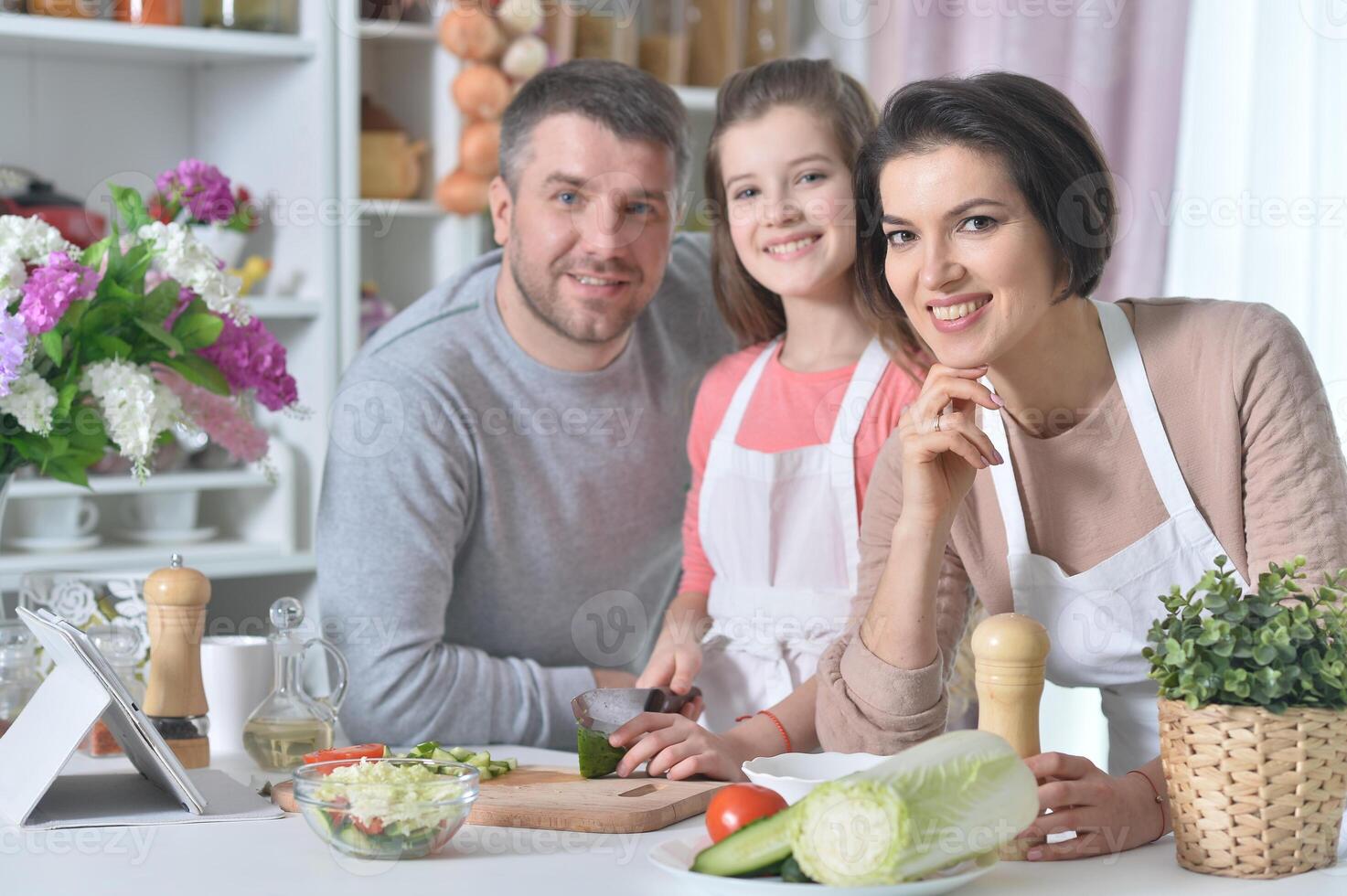 Portrait of young family cooking together at home photo