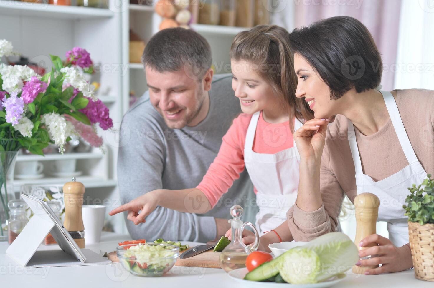 Portrait of young family cooking together at home photo