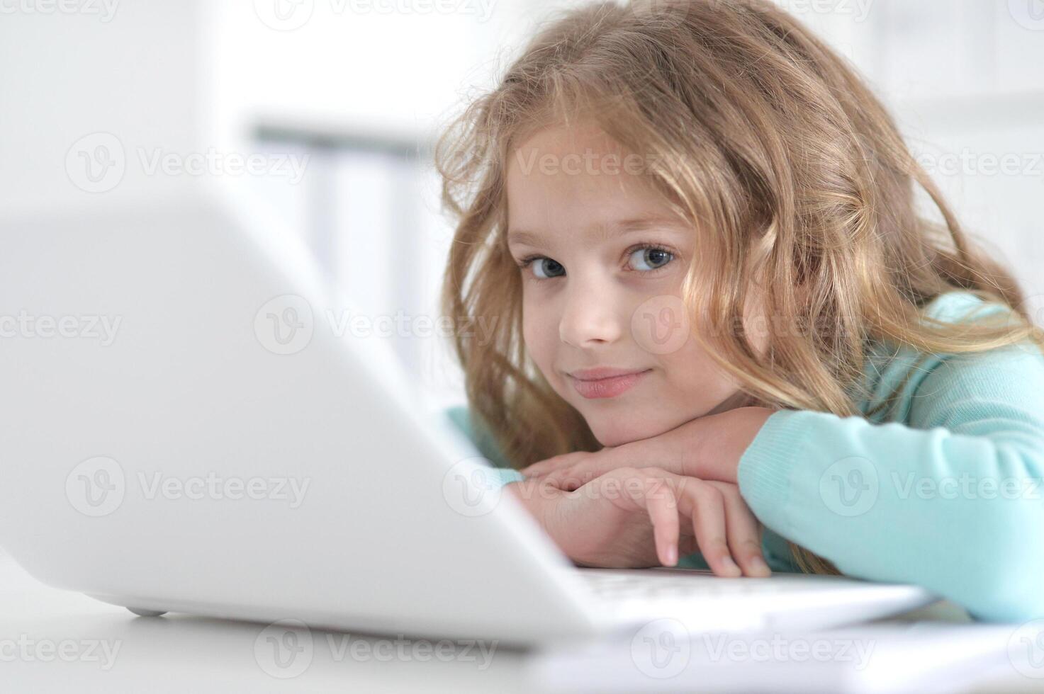 Cute and happy little girl children using laptop computer photo