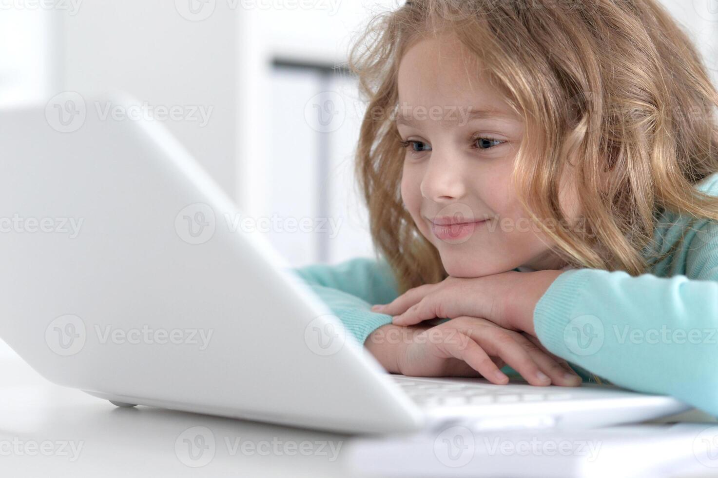 Cute and happy little girl children using laptop computer photo