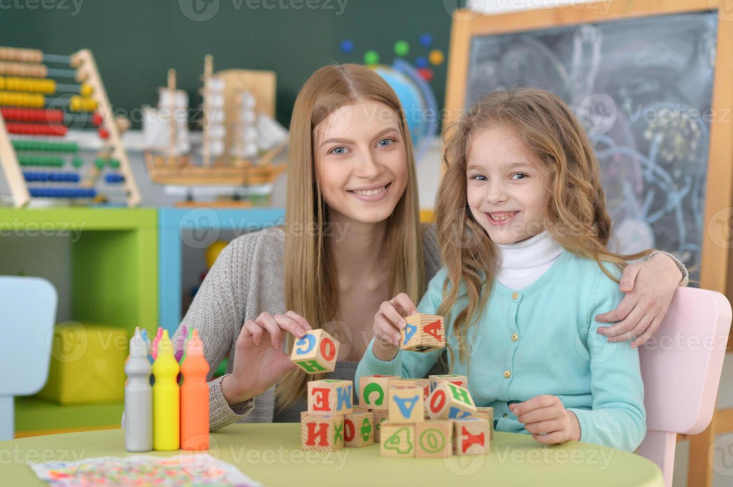 Portrait of little girl and her mother playing photo