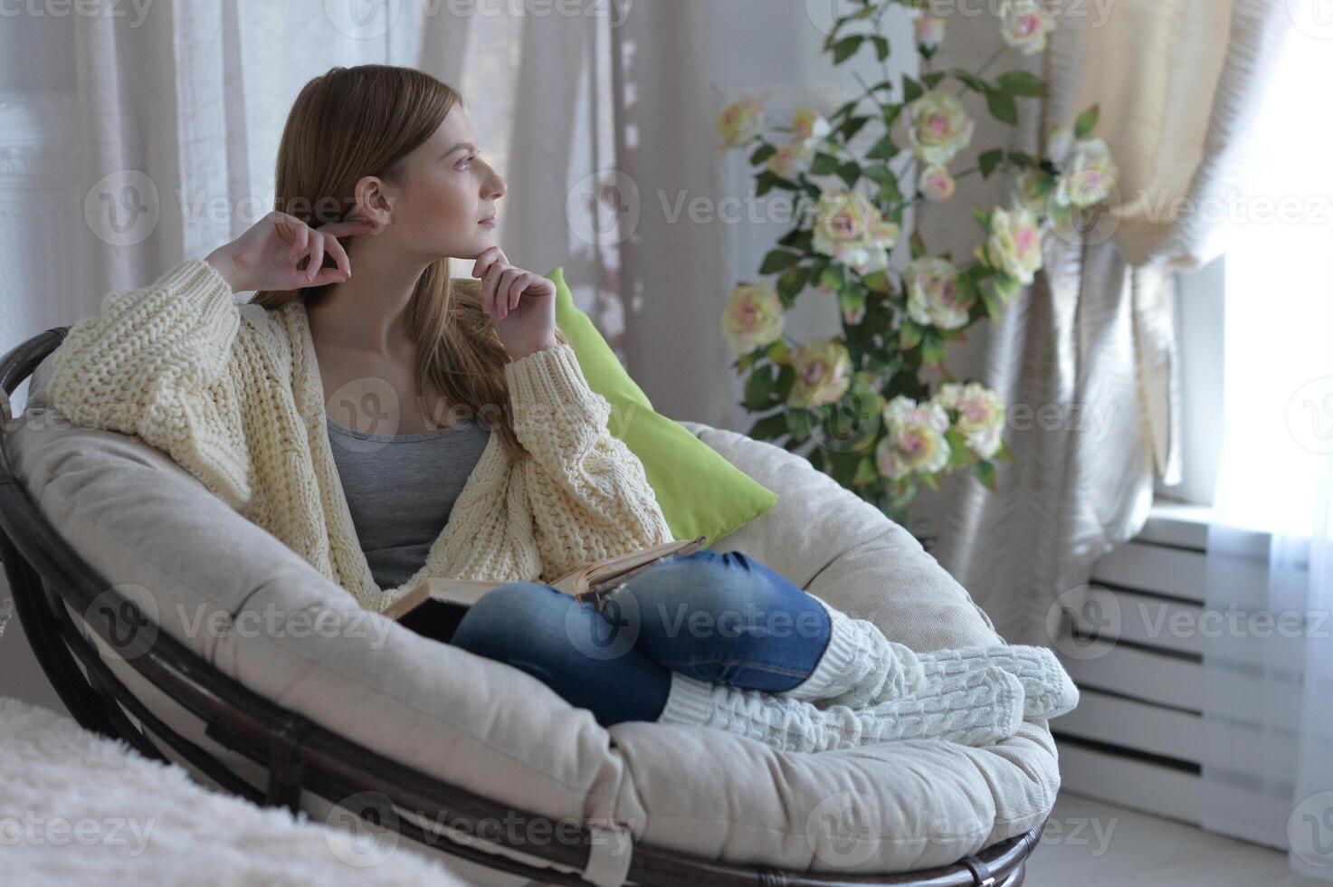 Portrait of young woman in pajamas on bed with fluffy plaid photo