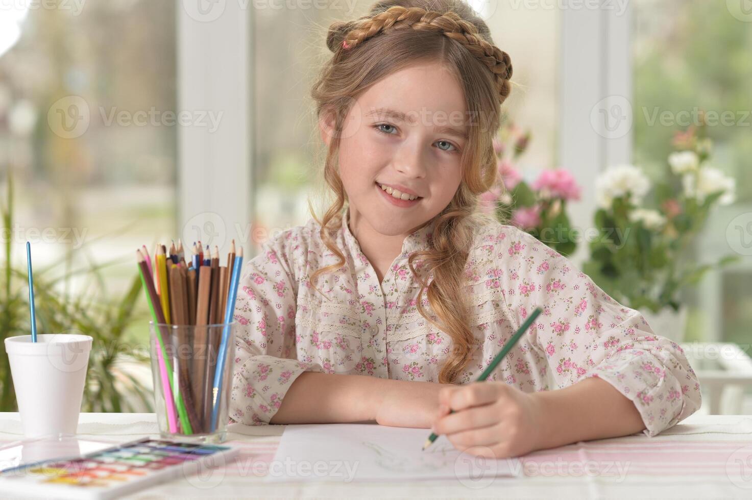 Cute smiling little girl drawing at home photo