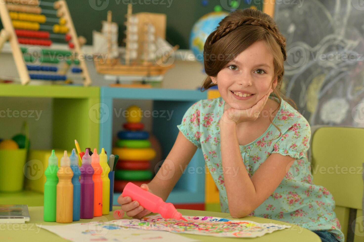 Portrait of cute girl drawing picture at home photo