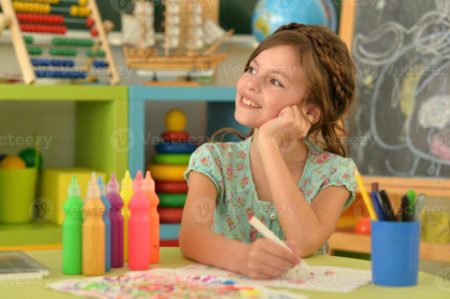 Portrait of cute girl drawing picture at home photo