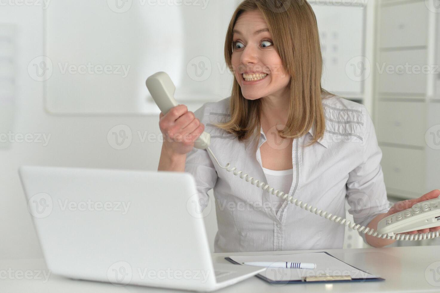 Female office worker reacting to phone call. photo