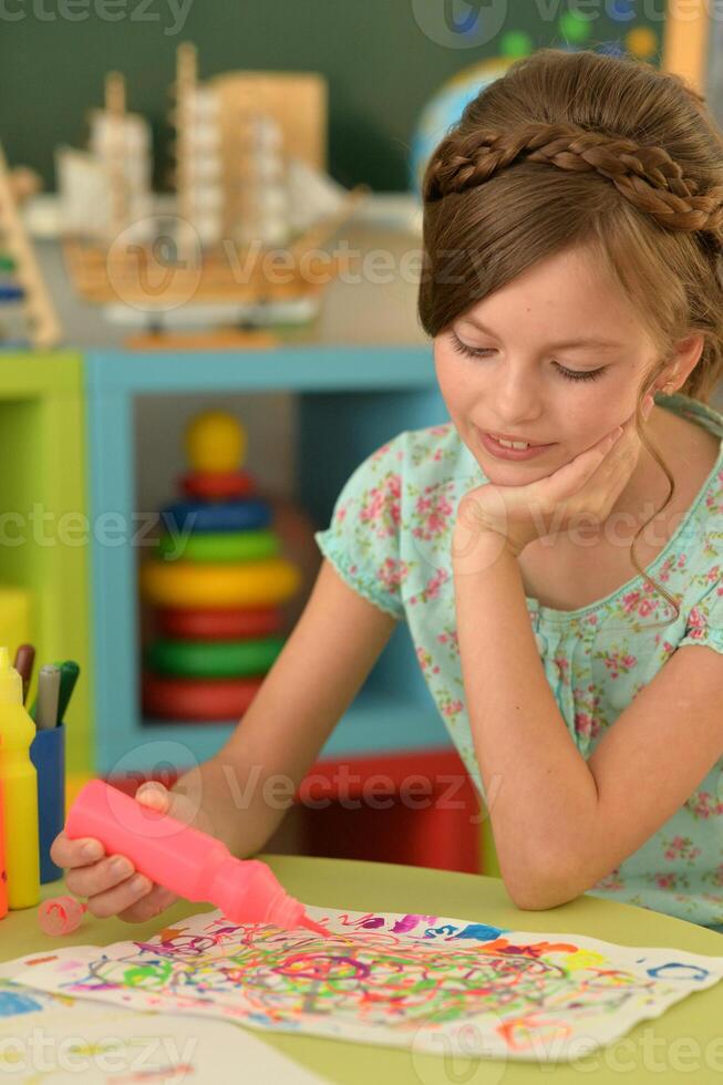 Portrait of cute girl drawing picture at home photo