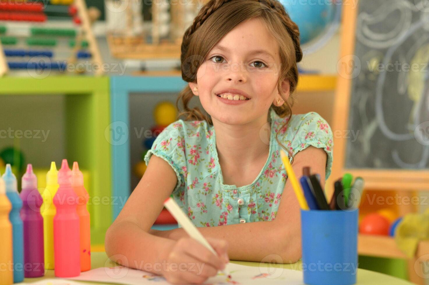 Portrait of cute girl drawing picture at home photo
