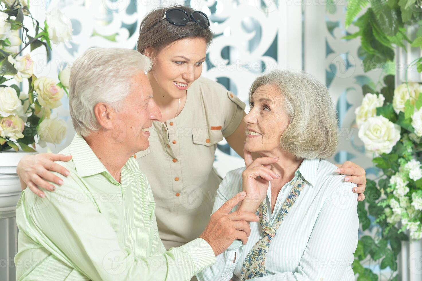 Portrait of happy senior couple with adult daughter photo