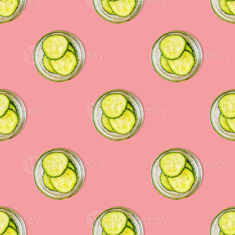 Seamless pattern of cucumber slices on a pink background photo