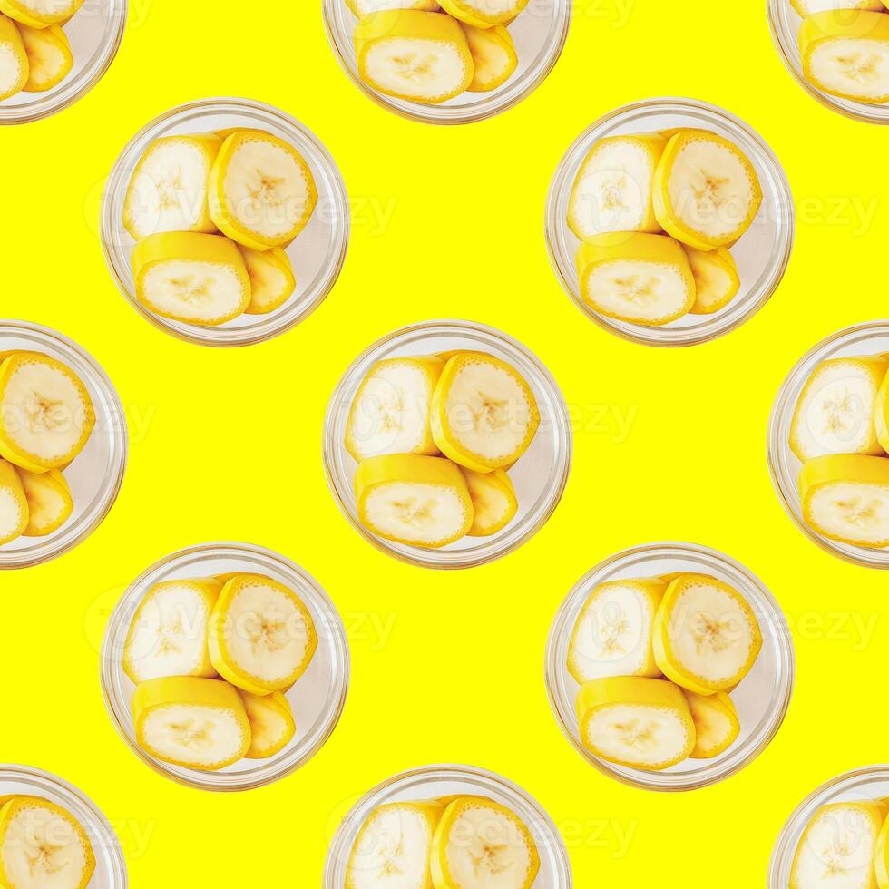 Seamless pattern of banana slices on a trendy yellow background photo