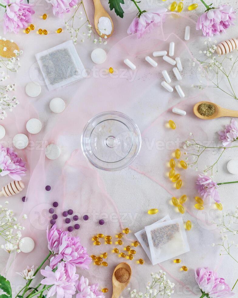 health care composition with vitamins, dietary supplements, herbal tea bags and a glass of water photo