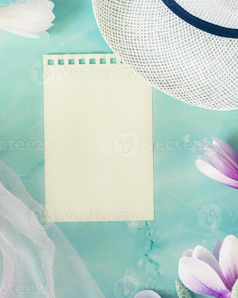 Spring light blue background with blooming magnolia flowers, a hat and a pink chiffon scarf photo