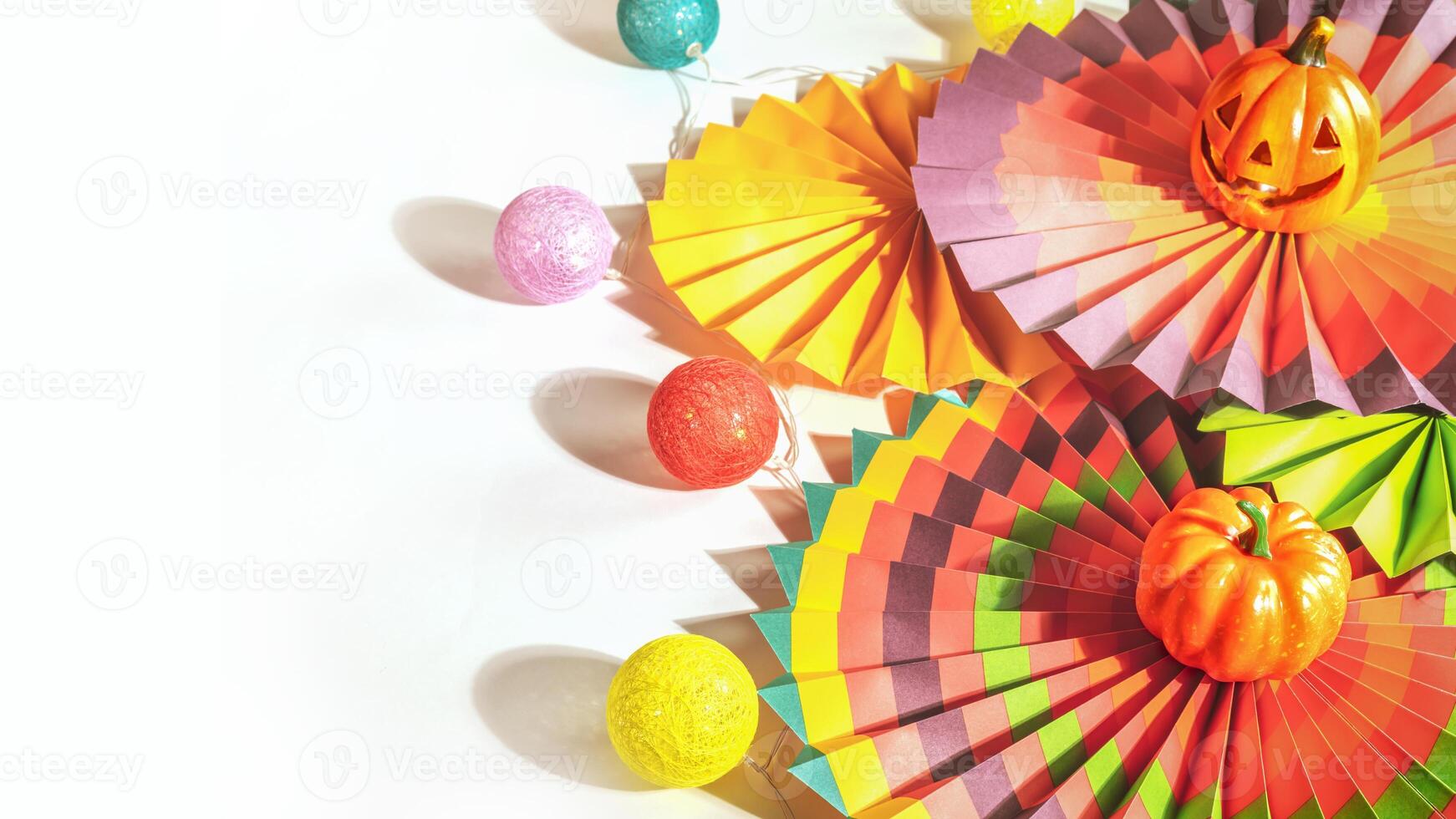 Colorful paper fans, decorative pumpkin, lightening and jack o'lantern photo