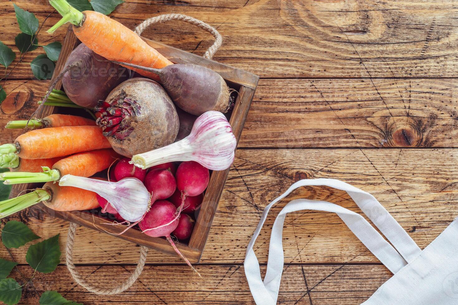 Wooden box full of fresh organic vegetables from the local market on a wooden table photo
