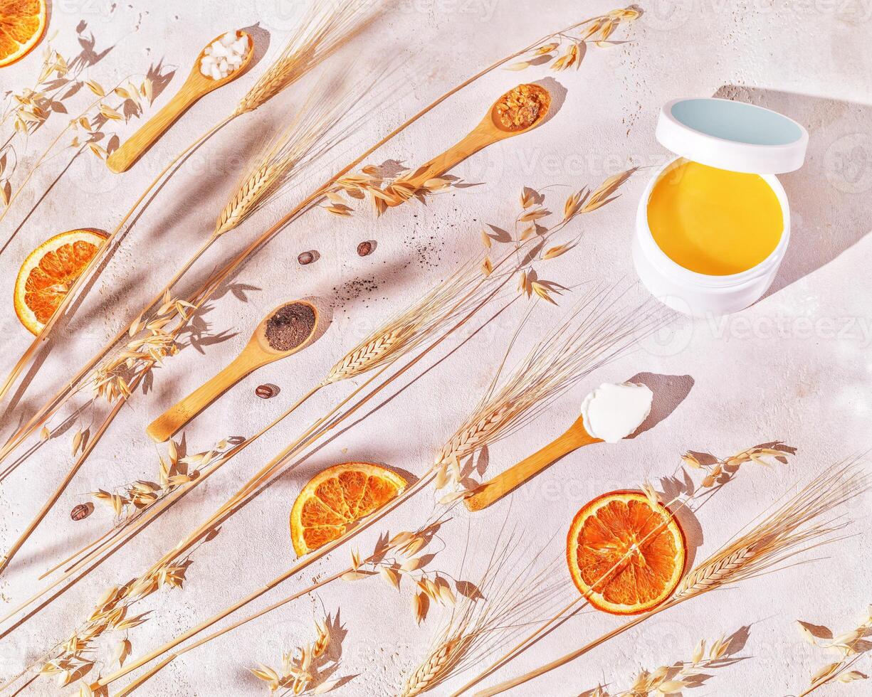 Spa composition with cosmetic jar of scrub and wooden spoons with natural ingredients photo