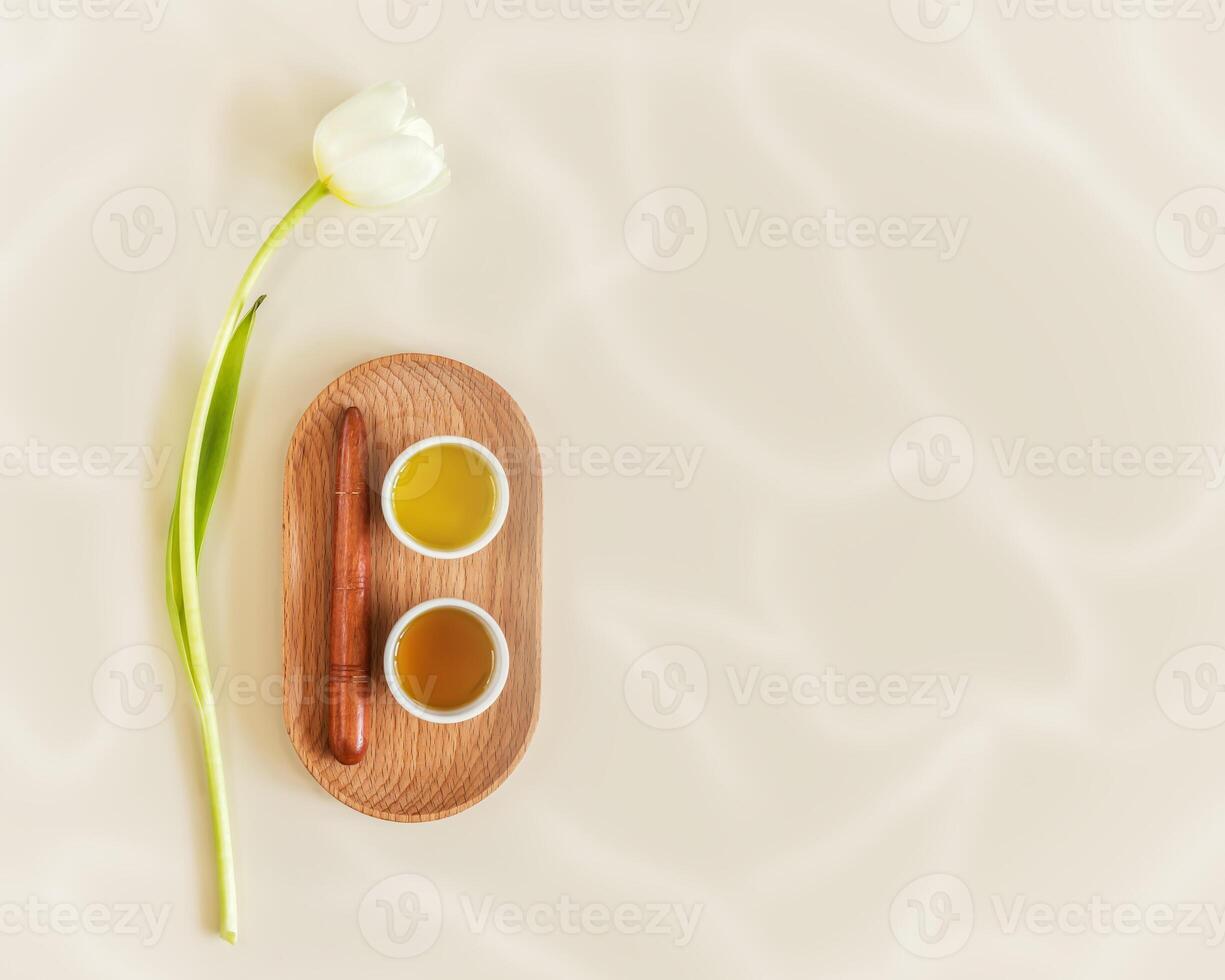 Light, spa, wellness composition with massage oil, massage stick and tulip photo