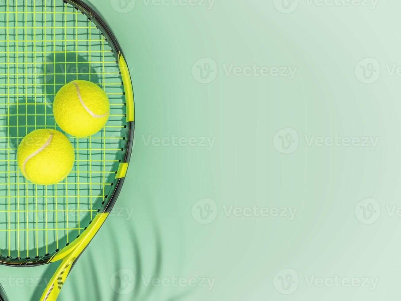 Yellow tennis ball and racket on a green background of tennis court with copy space photo