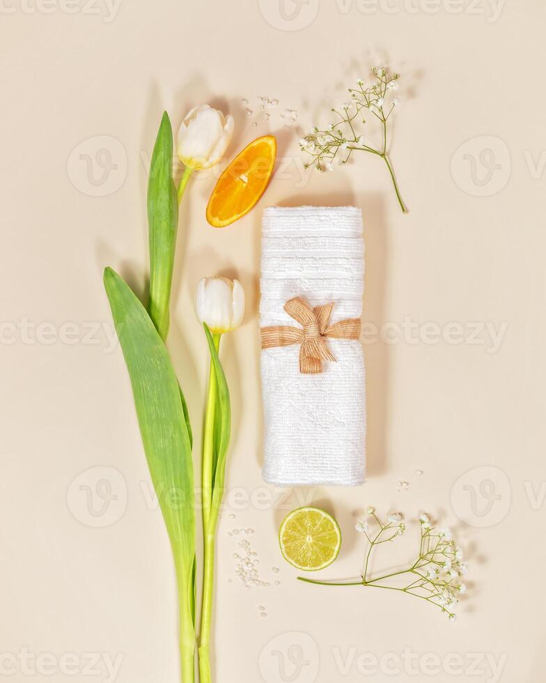 Relax, spa composition with white towel, tulips and citrus fruits on light background photo