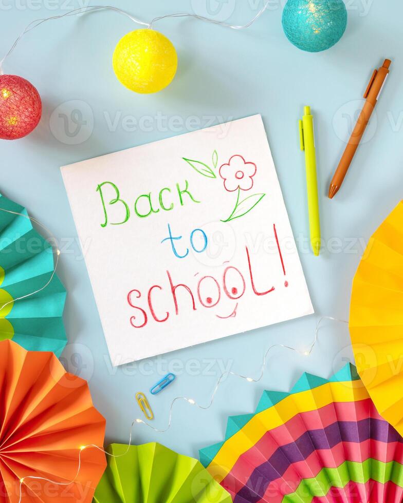 Holiday school composition with white sheet of paper with a child's drawing and inscription back to school photo