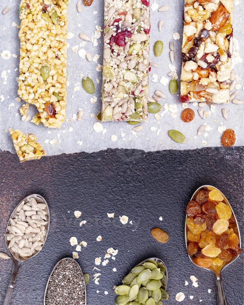 Granola cereal bars on a brown background with ingredients on spoons photo
