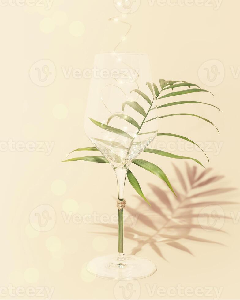 Empty glass with palm leaf and lightning on a pink background photo
