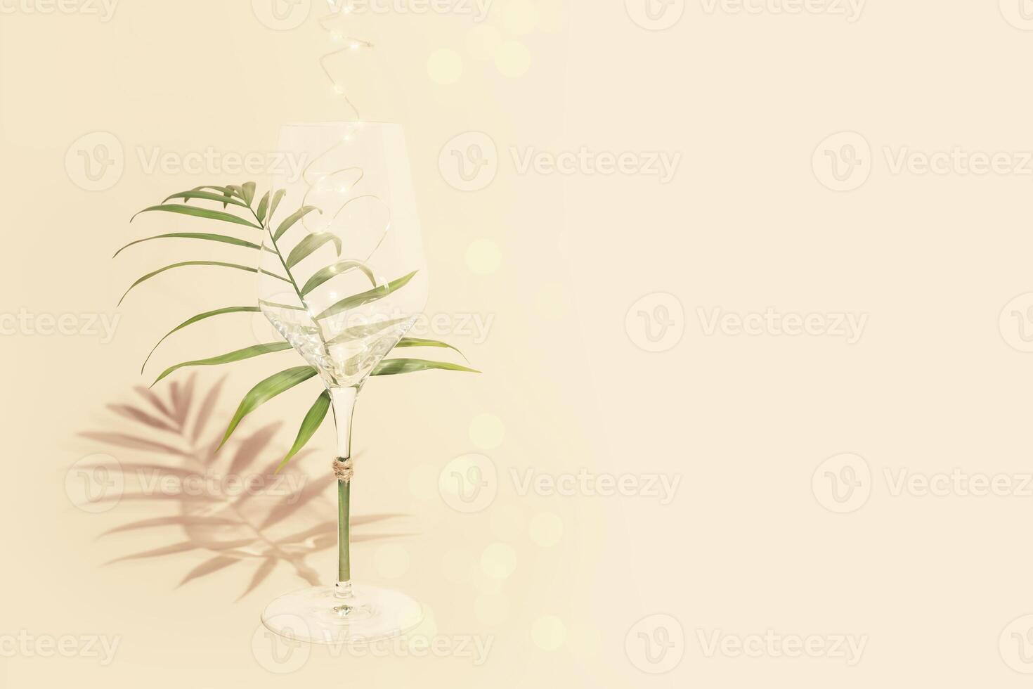 Empty glass with palm leaf and lightning on a pink background photo