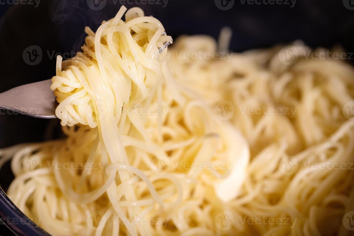 Hot traditional spaghetti in a saucepan and a piece of butter photo