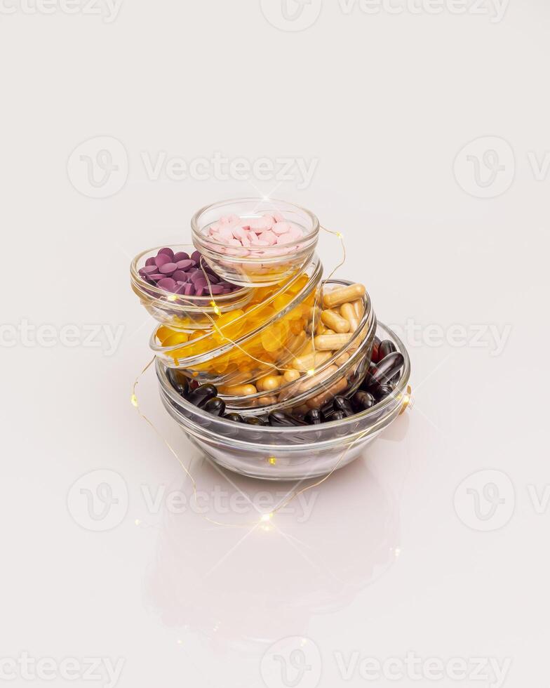 Different kind of vitamins in glass bowls with lighting garland on a white background with reflection photo
