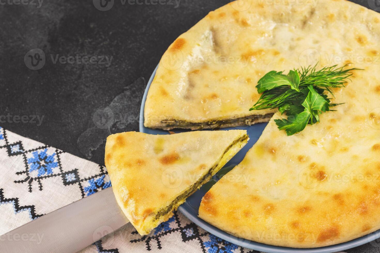 Ossetian pie with spinach on a black background photo