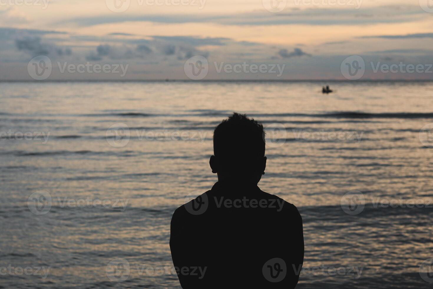 Silhouette of a Man on the Beach at Sunset photo