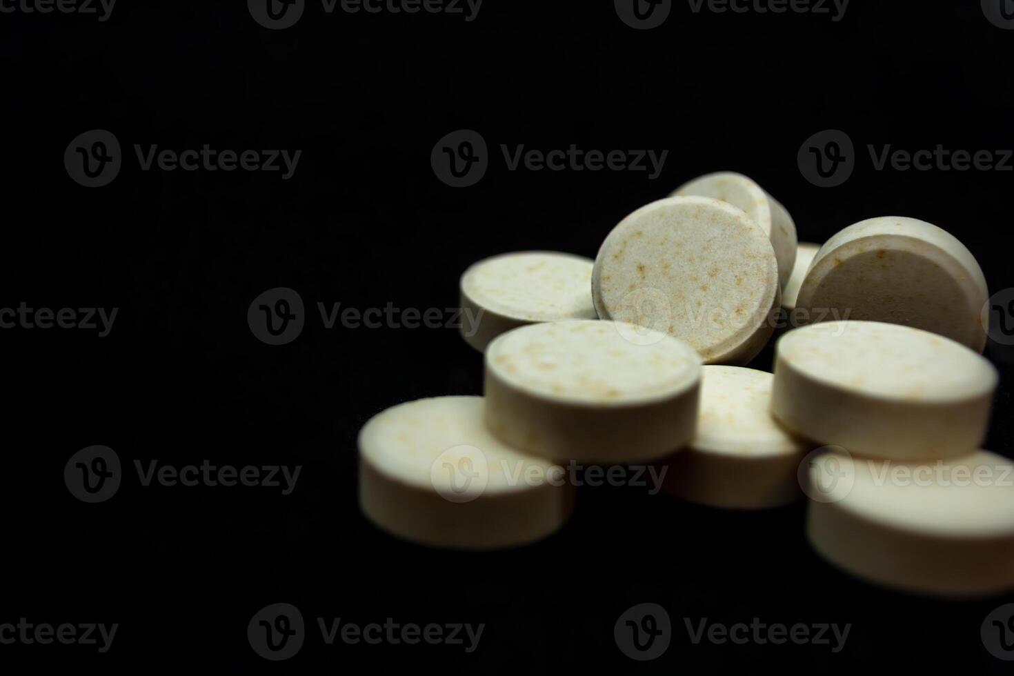 Pills on a black background. Focus on foreground, soft bokeh. photo