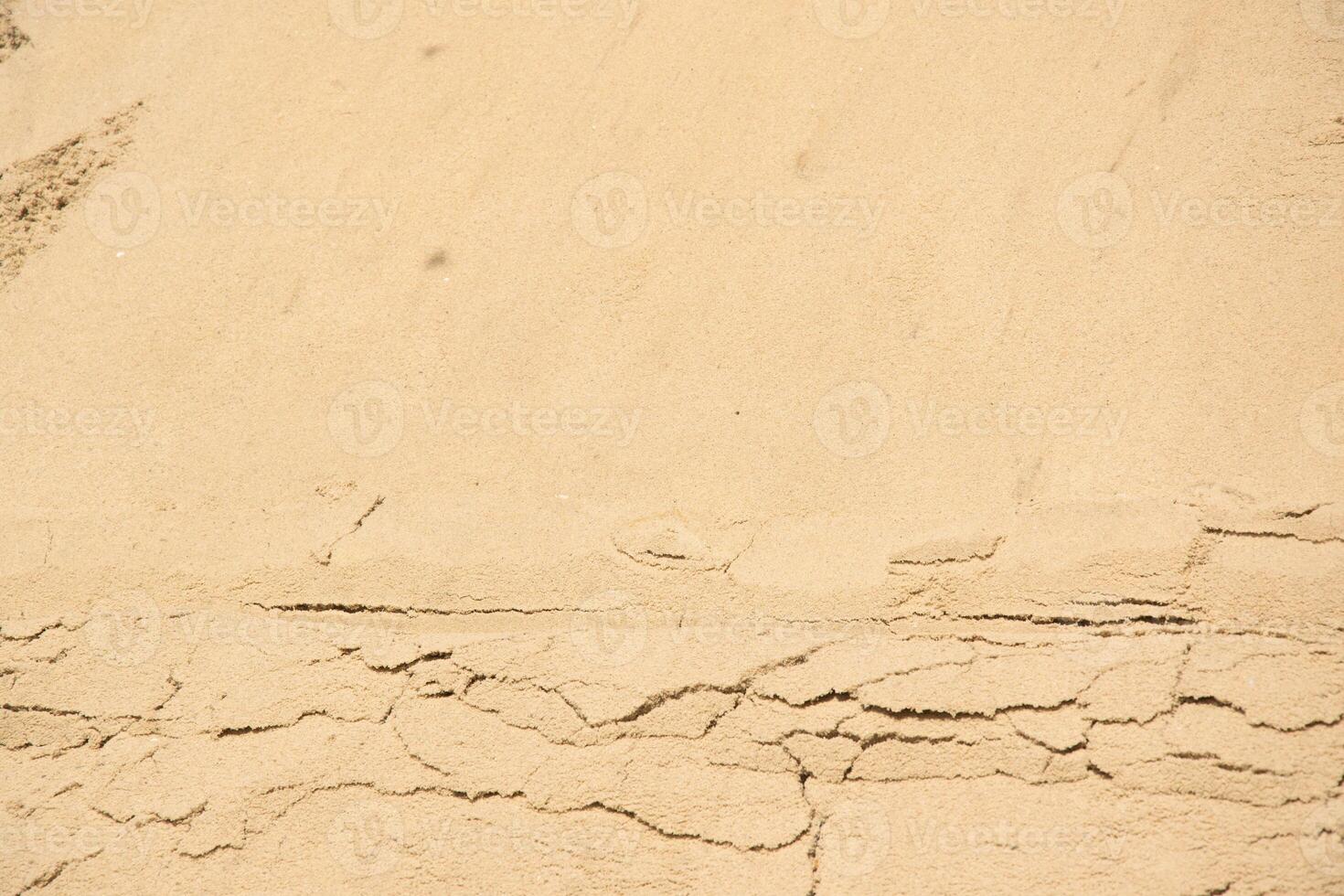 A close-up image of tan sand with visible cracks photo