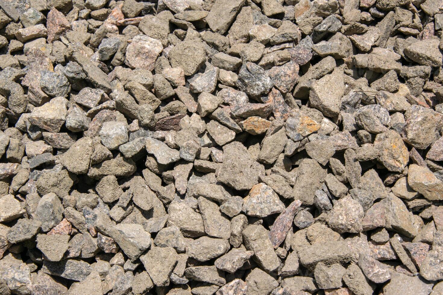 A close-up view of a pile of gray gravel stones in the sunlight photo