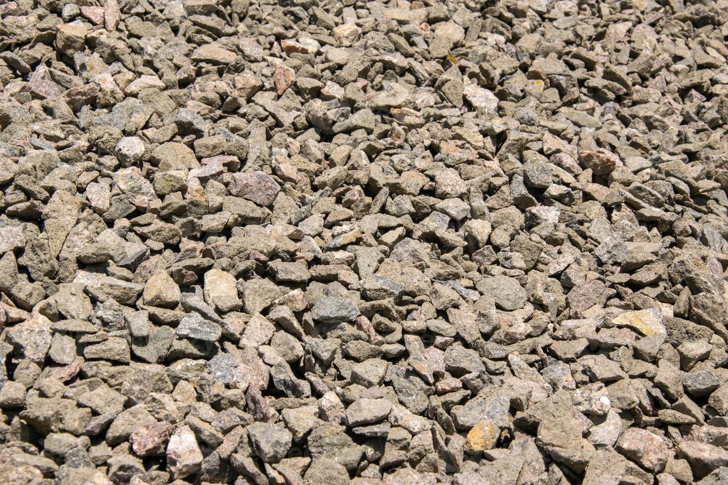 A close-up view of a gravel surface composed of small, gray, crushed stones photo