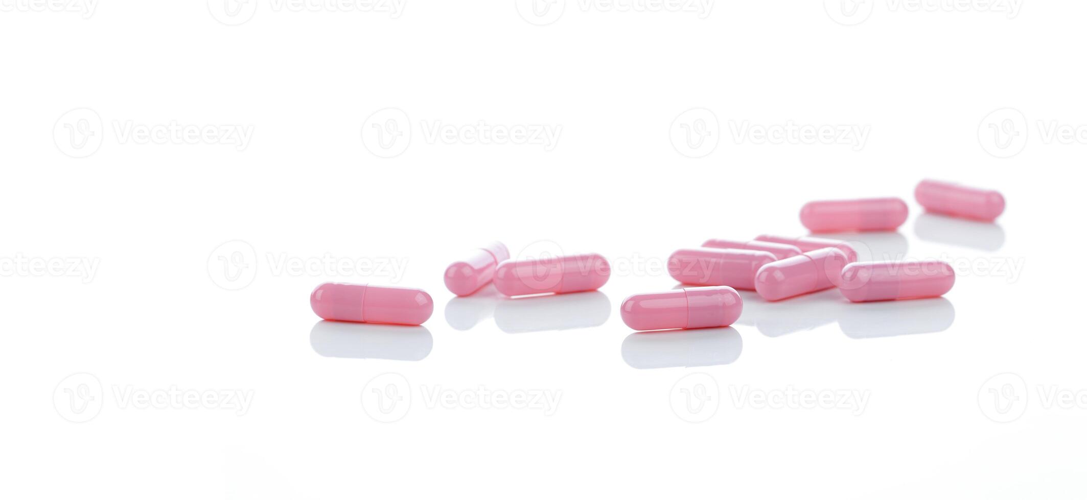Pink capsules pill spread on white background. Prescription drug. Pharmaceutical industry. Vitamin and supplement capsule. Pharmacy store banner. Pharmaceutical industry. Healthcare and medical care. photo