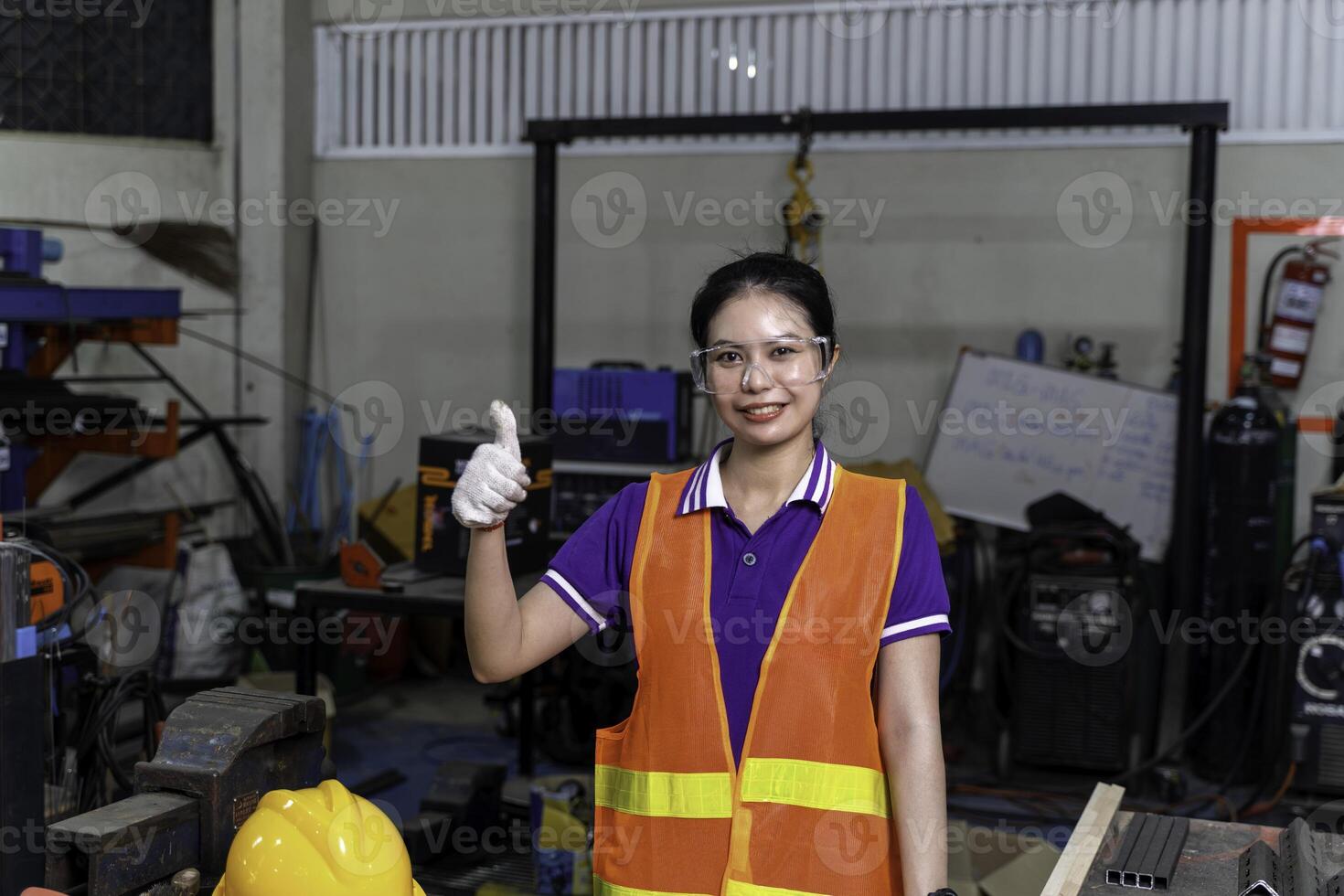 Construction worker, Asian woman engineer portrait of cheerful happy and thumbs up in industrial workshop. photo