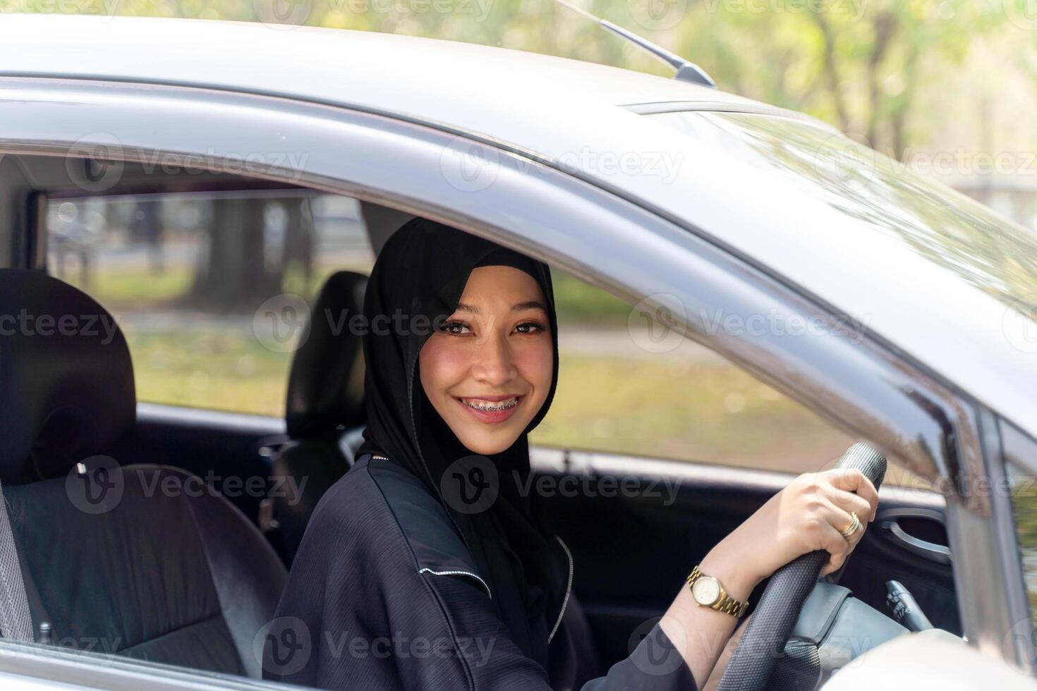 Closeup a beautiful Muslim woman in Abaya niqab traditional clothes driving a car in city photo